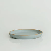 A 10'' blue stoneware plate with a swirl pattern on a white background.